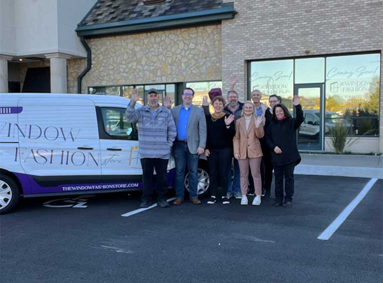Company staff posing for a photo out in the parking lot by the company van